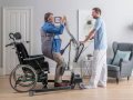 caregiver utilizza sollevatore verticalizzante per sollevare paziente da carrozzina posturale